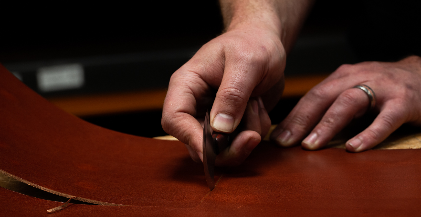 leatherworker cutting leather with round knife