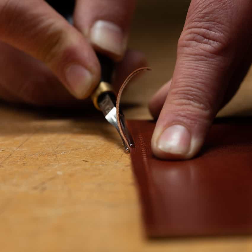 Leatherworker using an edge shave