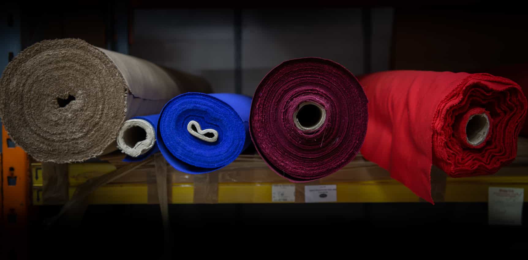 A mix of textiles rolled up on a shelf, textile wholesale